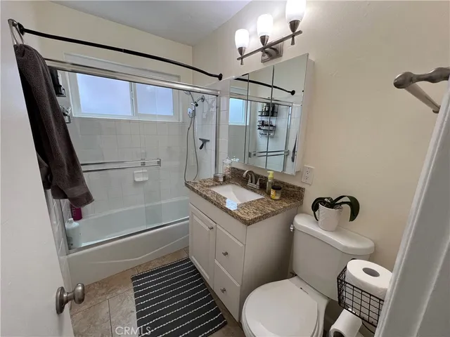 a bathroom with a sink a toilet a mirror and shower