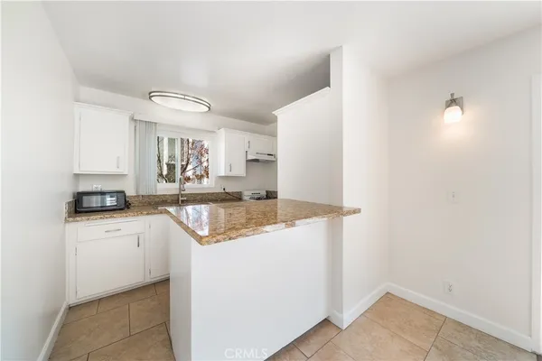 a kitchen with granite countertop a sink cabinets and refrigerator