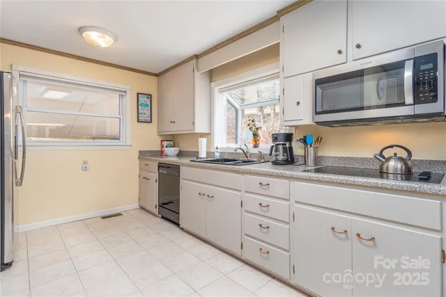 a kitchen with white cabinets stainless steel appliances and sink
