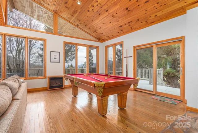 a room with pool table and windows