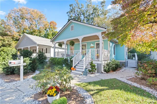 a front view of a house with a yard and potted plants