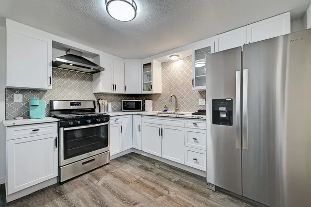 a kitchen with a refrigerator and a stove top oven