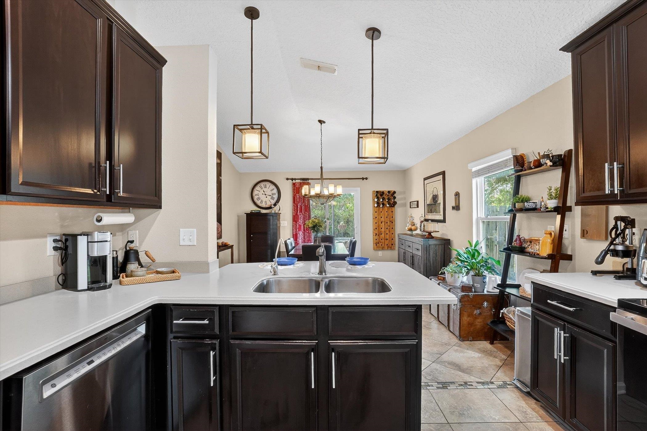 137 Fallen Timber Way St. Augustine, FL 32084 - Photo 1 of 45 Kitchen with a peninsula, light countertops, dark wood finish cabinetry, and dishwasher