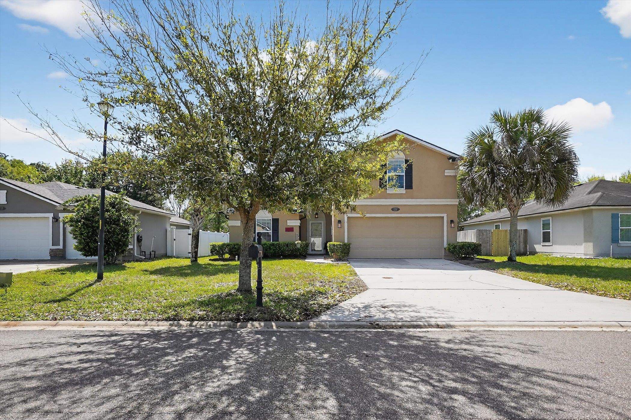 137 Fallen Timber Way St. Augustine, FL 32084 - Photo 34 of 45 View of property hidden behind natural elements featuring concrete driveway, stucco siding, a garage, and a residential view