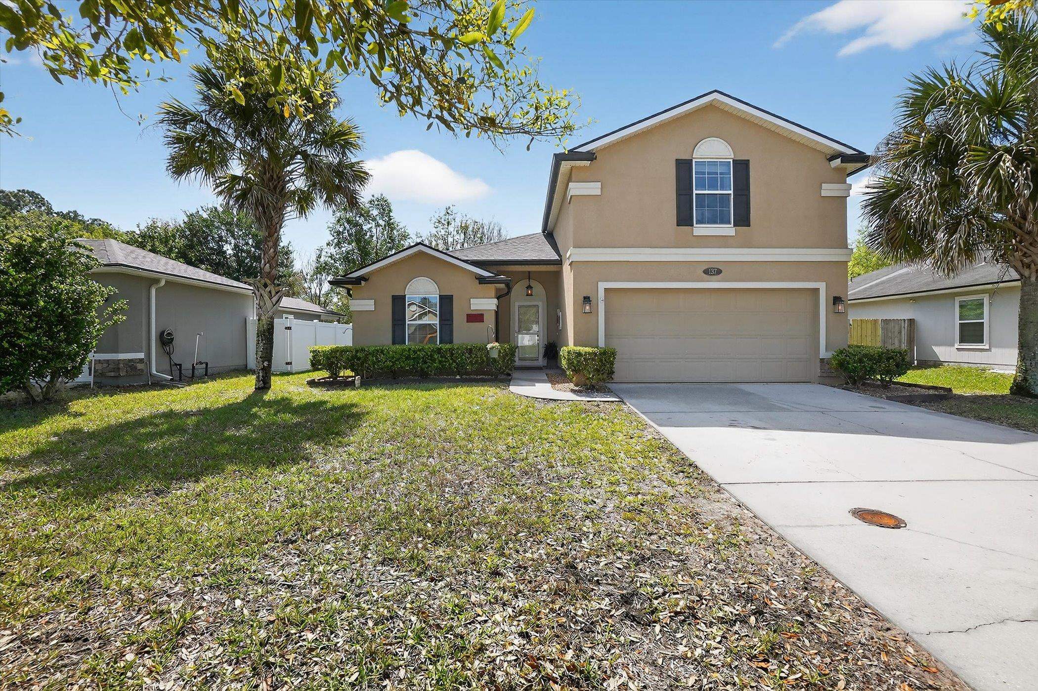 137 Fallen Timber Way St. Augustine, FL 32084 - Photo 35 of 45 Traditional-style home with stucco siding, concrete driveway, an attached garage, and a gate