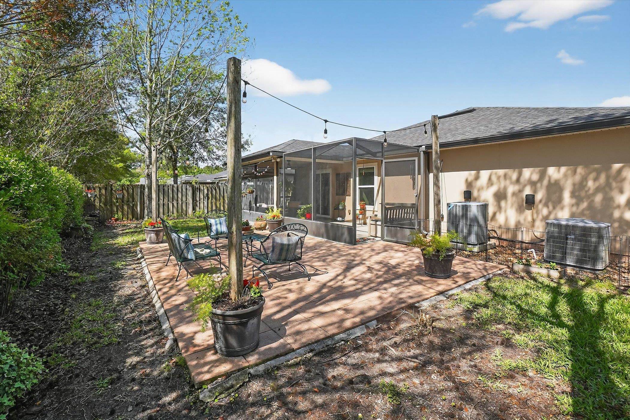 137 Fallen Timber Way St. Augustine, FL 32084 - Photo 42 of 45 Back of property with a patio, a sunroom, and a fenced backyard