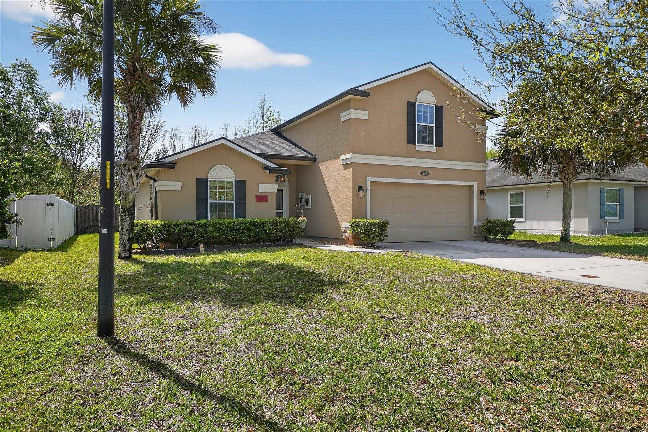 137 Fallen Timber Way St. Augustine, FL 32084 - Photo 5 of 45 Traditional-style home with stucco siding, a garage, driveway, and a front lawn
