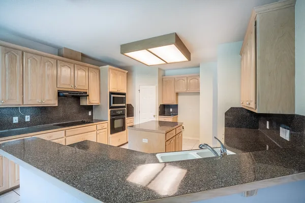 a kitchen with stainless steel appliances granite countertop a sink refrigerator and cabinets