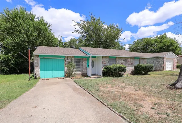 a front view of a house with a garden and yard