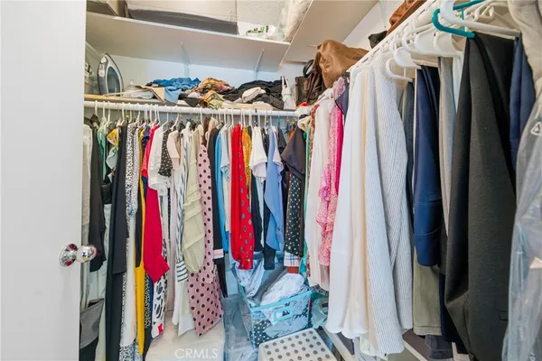 a view of walk in closet with clothes