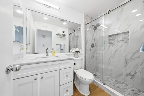 a bathroom with a sink a toilet and shower