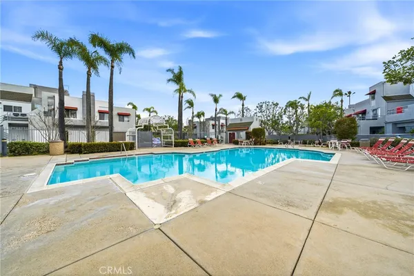 a view of swimming pool with outdoor seating and palm