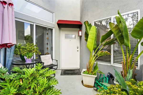 a front view of a house with outdoor seating and flowers