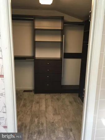 a view of walk in closet with empty racks