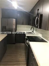 a kitchen with a sink and a mirror