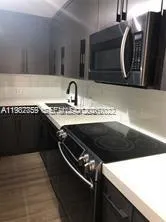 a kitchen with a sink a stove and cabinets