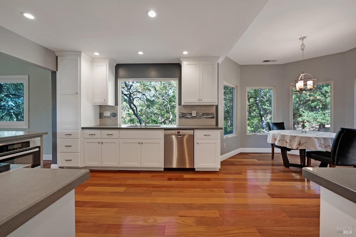 4727 Woodview Drive Santa Rosa, CA 95405 - Photo 18 of 46 a kitchen with stainless steel appliances granite countertop a stove a sink a refrigerator and a dining table with wooden floor