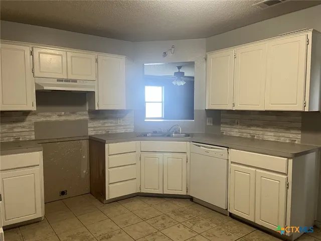 a kitchen with cabinets appliances and a window