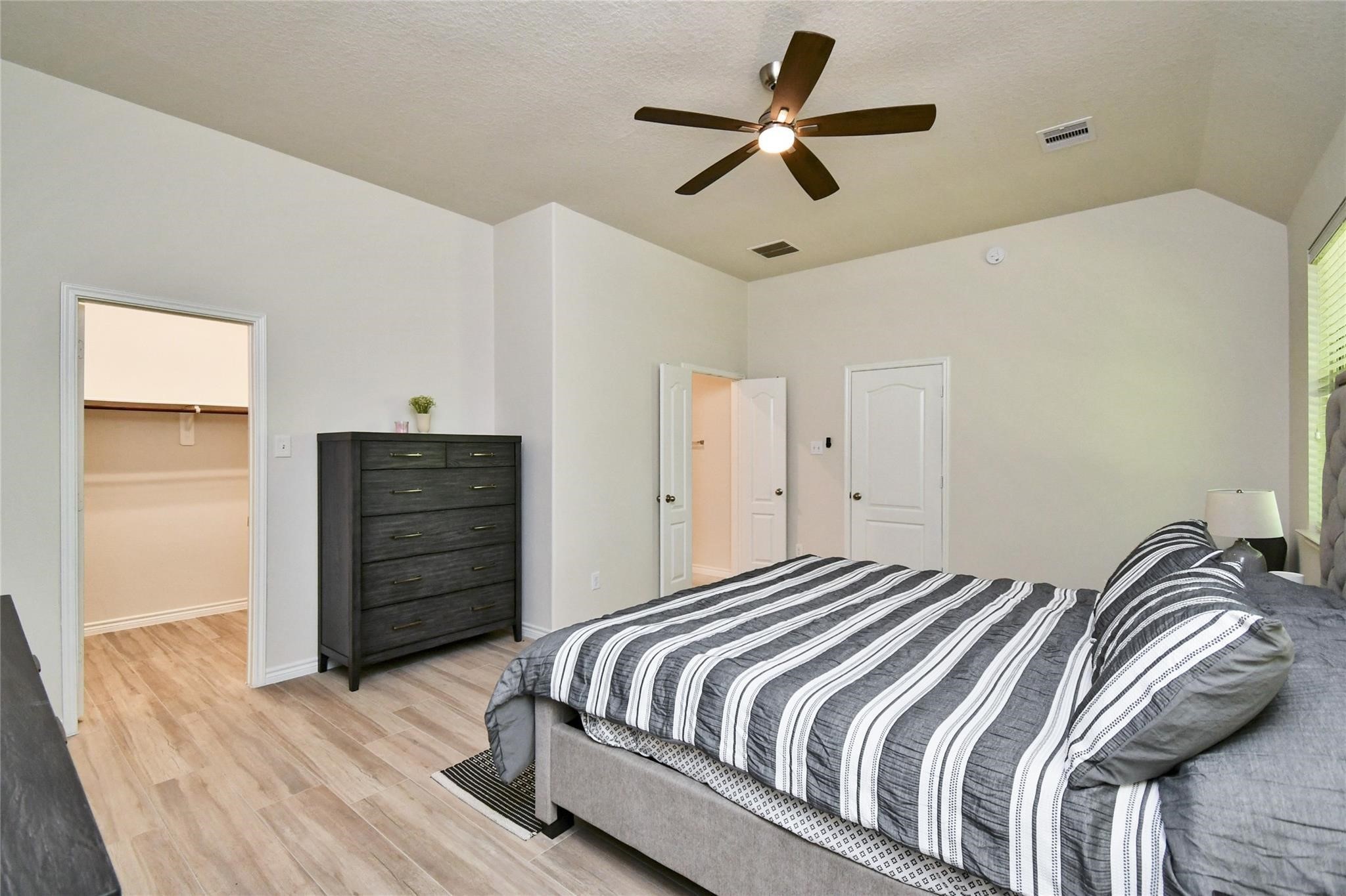 22 Wood Drake Place Tomball, TX 77375 - Photo 11 of 21 a bedroom with a bed and a chandelier