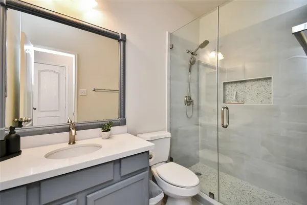 a bathroom with a sink toilet a mirror and shower