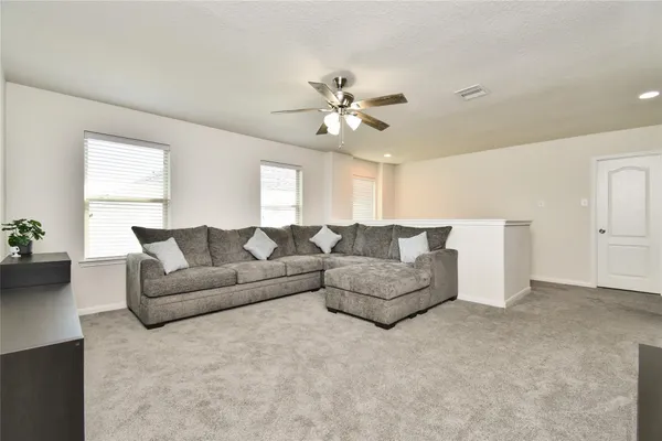 a living room with furniture and a ceiling fan