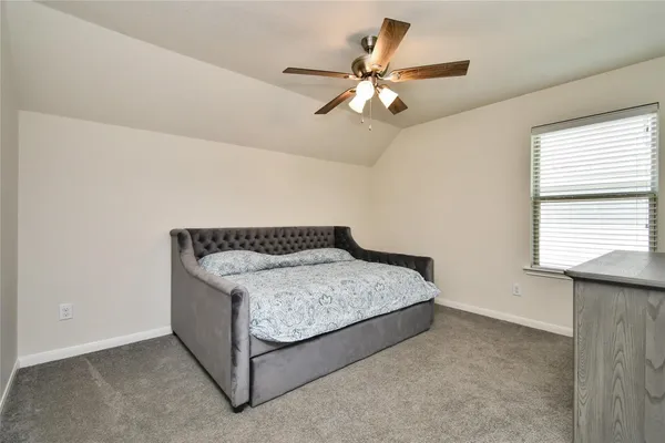 a spacious bedroom with a bed and a chandelier