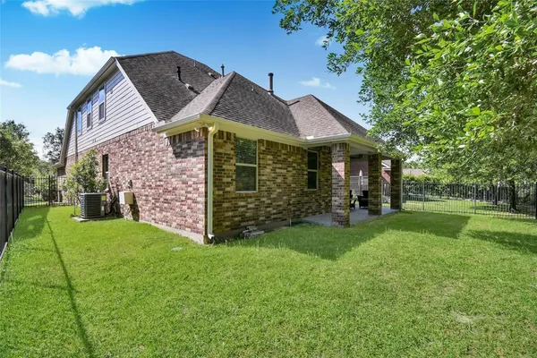 a view of a big house with a big yard and large trees