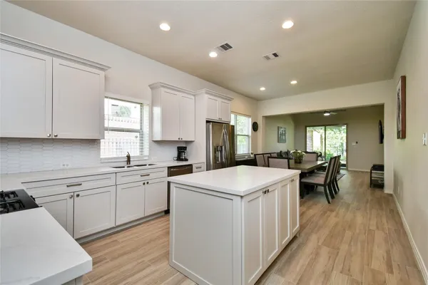 a kitchen with a sink a counter top space stainless steel appliances and windows