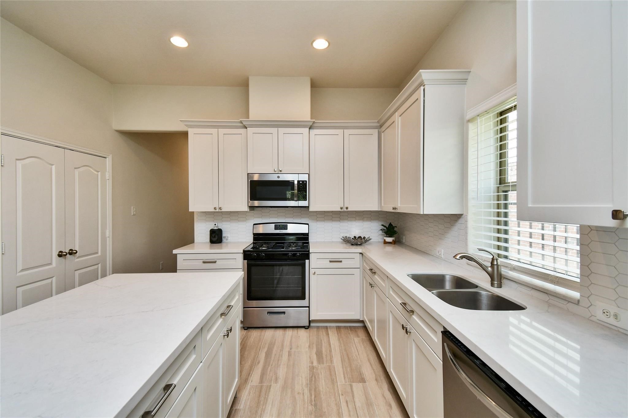 22 Wood Drake Place Tomball, TX 77375 - Photo 8 of 21 a kitchen with stainless steel appliances a white stove top oven sink and cabinets