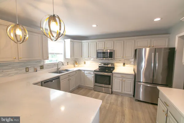 a kitchen with a sink cabinets and wooden floor