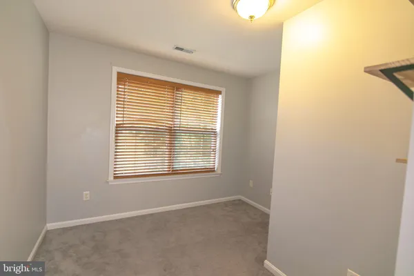 a view of empty room with stairs and wooden floor