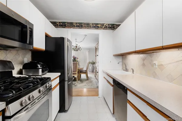 a kitchen with stainless steel appliances a sink dishwasher a stove and a refrigerator