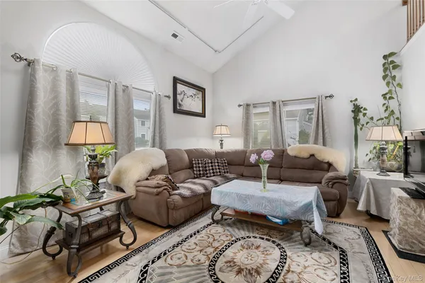 a living room with furniture wooden floor and a lamp