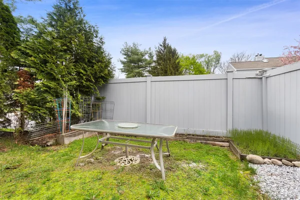 a view of a backyard with table and chairs and wooden fence