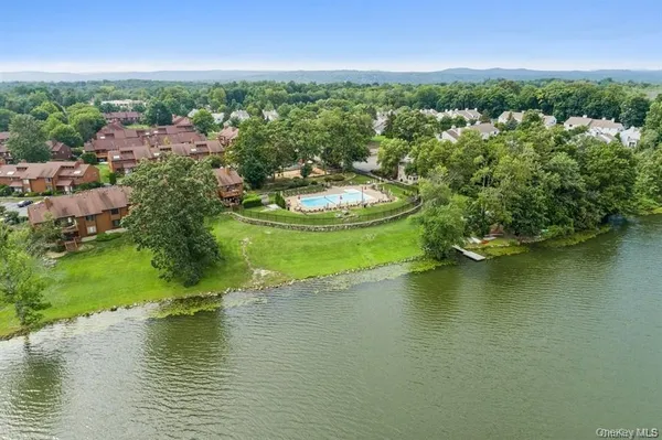 an aerial view of a house with a yard lake view and mountain view in back