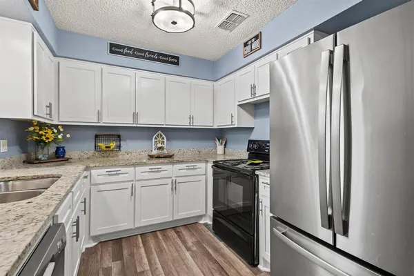 a kitchen with stainless steel appliances granite countertop a refrigerator sink and stove