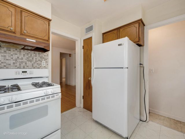 a white refrigerator freezer and a stove sitting inside of a kitchen