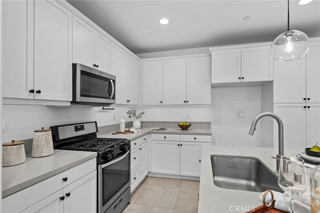9463 Retreat Place Rancho Cucamonga, CA 91730 - Photo 12 of 37 a kitchen with stainless steel appliances granite countertop a sink a stove a microwave and cabinets