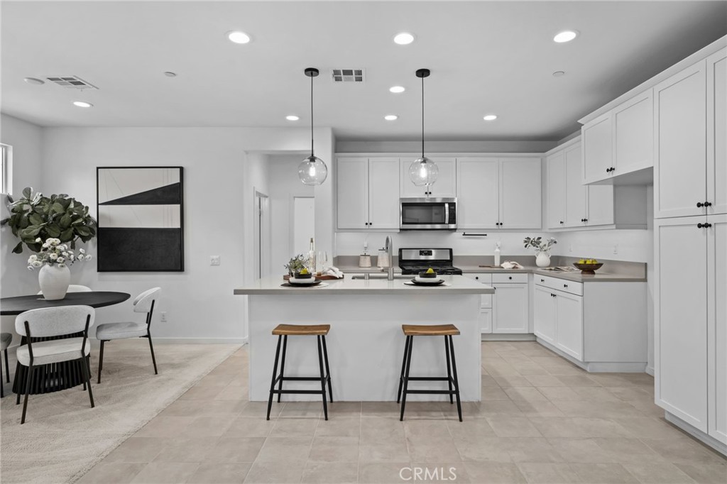 9463 Retreat Place Rancho Cucamonga, CA 91730 - Photo 2 of 37 a kitchen with white cabinets and chairs