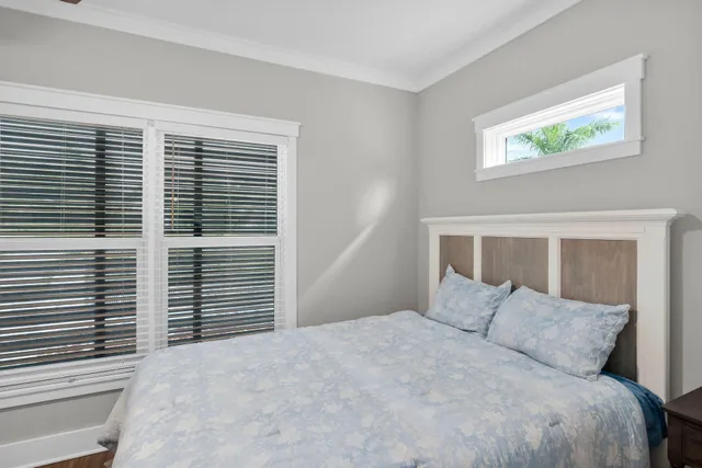 a large white bed in a bedroom next to a window