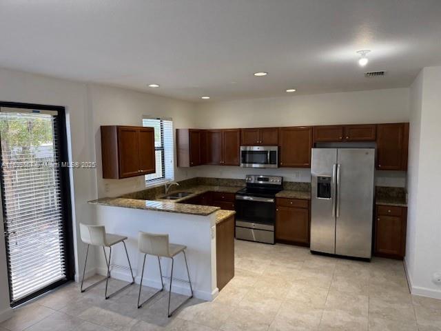 23705 Southwest 117th Court Homestead, FL 33032 - Photo 5 of 22 a kitchen with stainless steel appliances granite countertop a stove a sink and a refrigerator