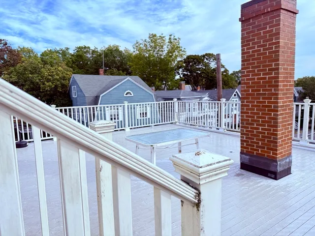 a view of a balcony with wooden floor and fence
