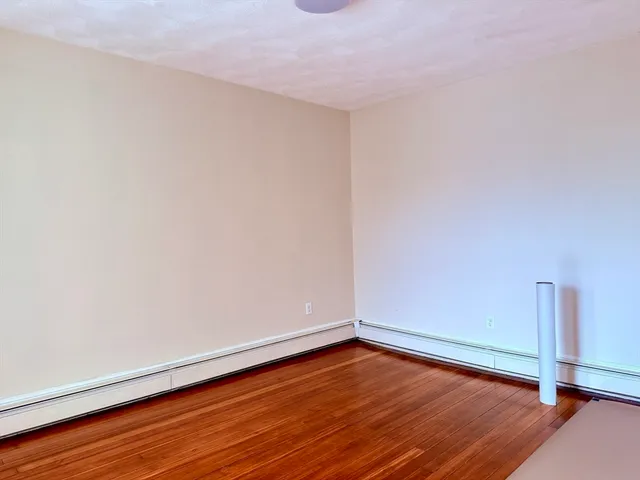 a view of an empty room with wooden floor