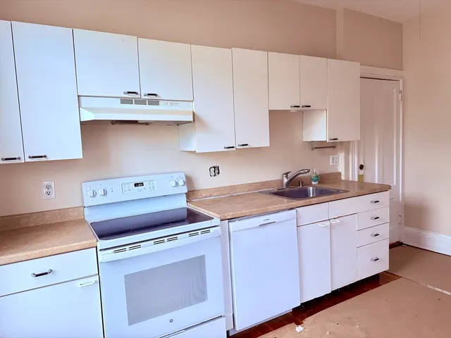 a kitchen with cabinets appliances a sink and a stove