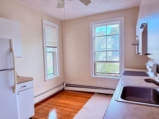 a view of a livingroom with a window and hardwood floor