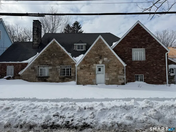 a view of a house with a yard covered in snow