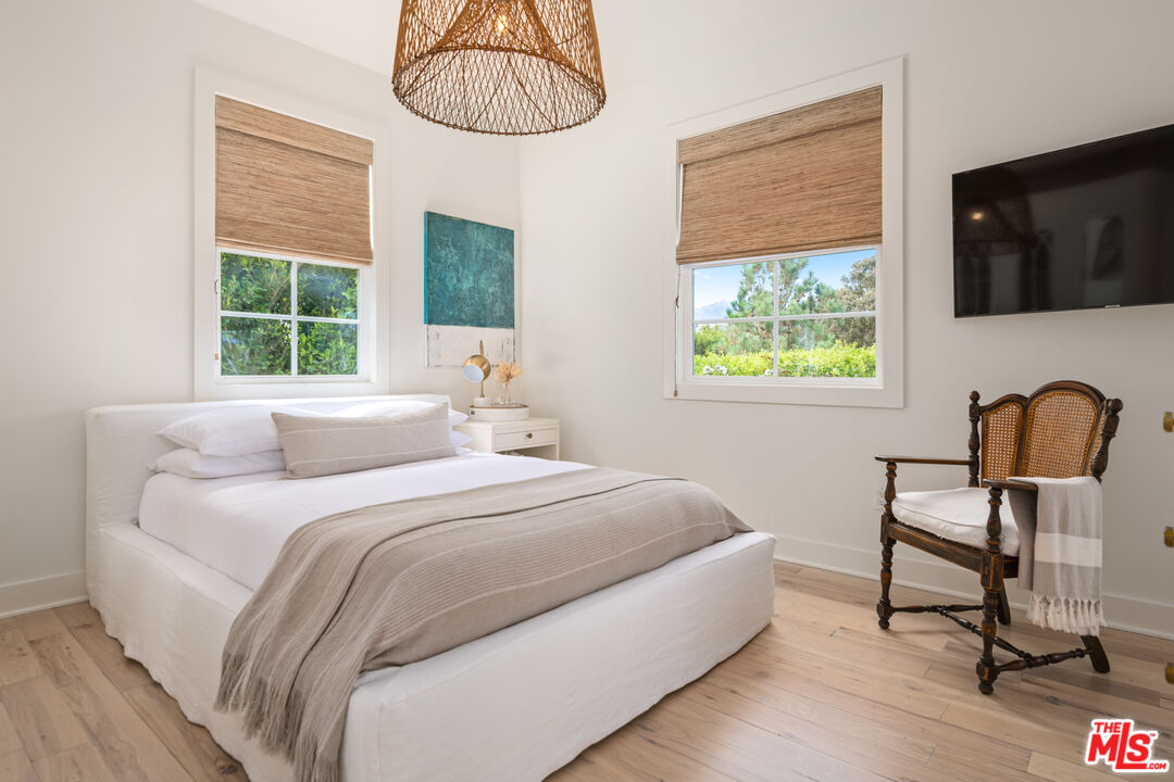 28870 Hampton Place Malibu, CA 90265 - Photo 31 of 53 a bedroom with a bed a flat screen tv and a window