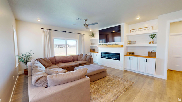 1127 4240 North Enoch, UT 84721 - Photo 14 of 56 Living room with light wood-style floors, ceiling fan, a large fireplace, built in shelves, and recessed lighting