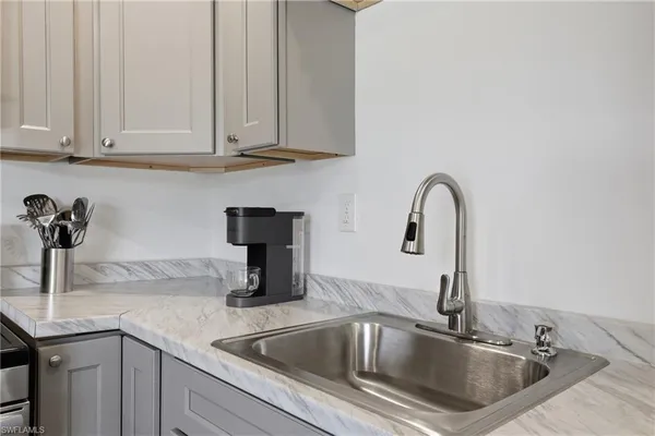 a kitchen with stainless steel appliances kitchen island granite countertop a sink a stove and microwave