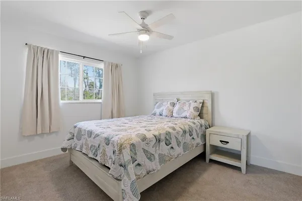 a large bed sitting in a bedroom next to a window